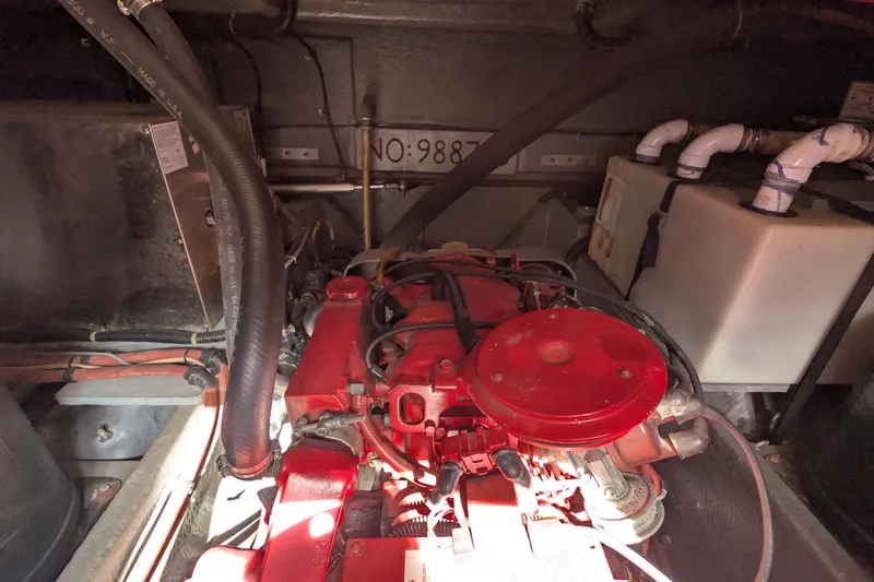 Slide: The Image of Engine compartment of a 1987 Sea Ray 390 Express Cruiser with red engine components. - 49