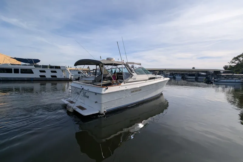 Slide: The Image of 1987 Sea Ray 390 Express Cruiser docked in a marina under a clear sky. - 5