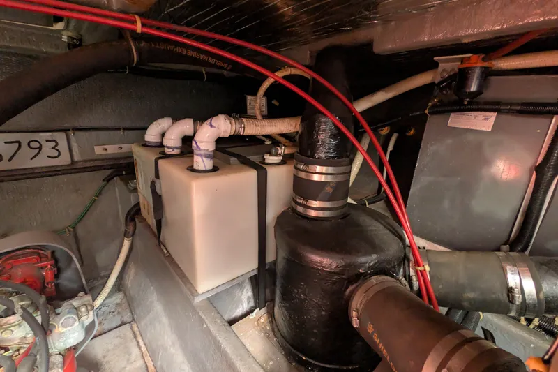 Slide: The Image of Engine room of 1987 Sea Ray 390 Express Cruiser with visible plumbing and wiring. - 50