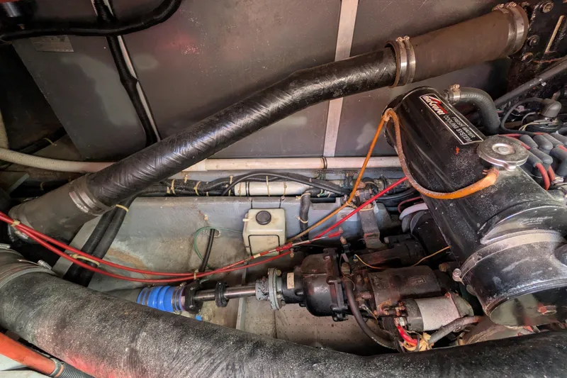 Slide: The Image of Engine compartment of a 1987 Sea Ray 390 Express Cruiser, showing mechanical components and wiring. - 52