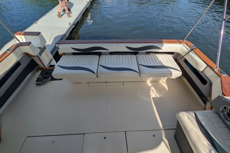 Slide: The Image of 1987 Sea Ray 390 Express Cruiser interior with seating, dockside view. - 8