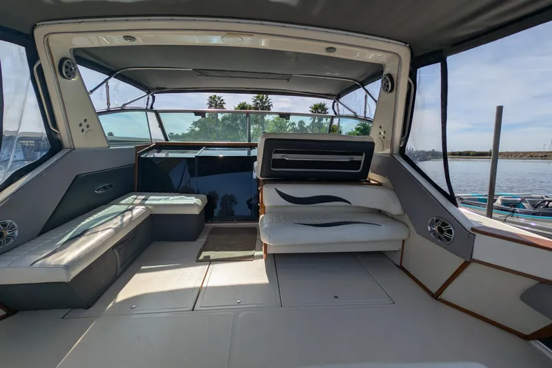 Slide: The Image of 1987 Sea Ray 390 Express Cruiser interior with seating, windows, and water view. - 9