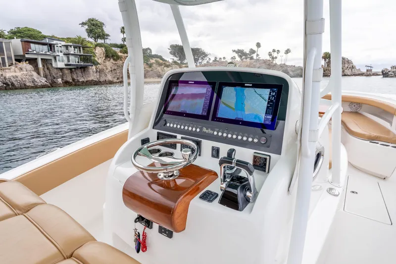 Slide: The Image of 2015 Mag Bay 33 CC boat dashboard with navigation screens and steering wheel. - 14