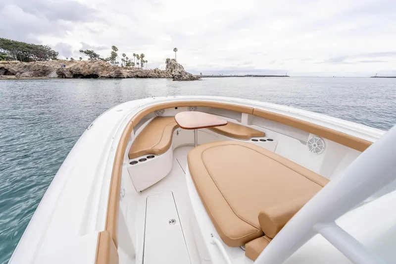 Slide: The Image of 2015 Mag Bay 33 CC boat interior with tan seating and ocean view. - 17