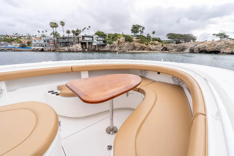 Slide: The Image of Luxurious seating area on 2015 Mag Bay 33 CC boat with scenic coastal view. - 19