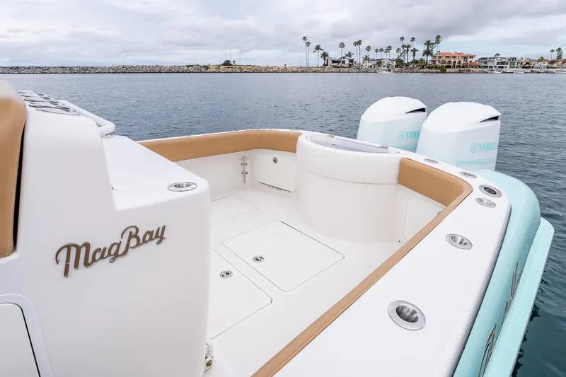 Slide: The Image of 2015 Mag Bay 33 CC boat with Yamaha engines, docked near a coastal area. - 22