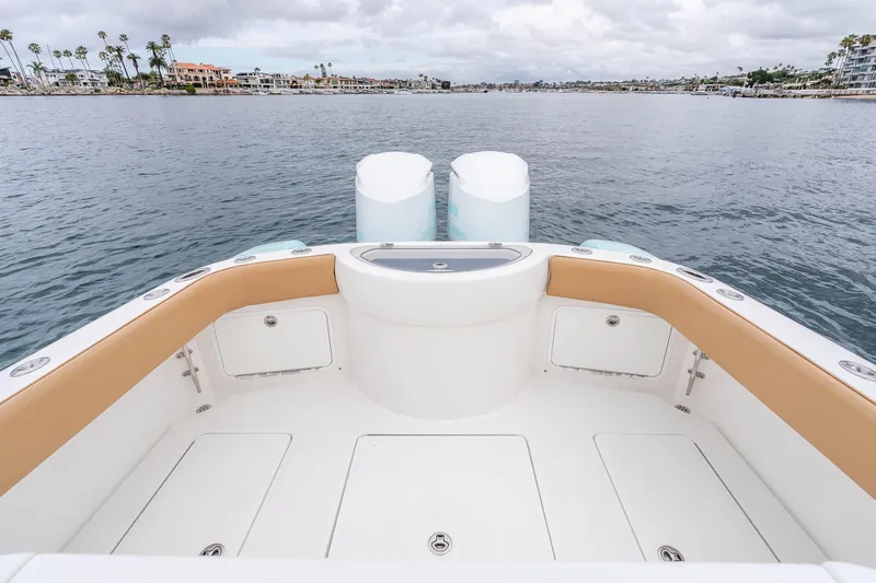 Slide: The Image of 2015 Mag Bay 33 CC boat stern view with twin engines on calm water. - 23
