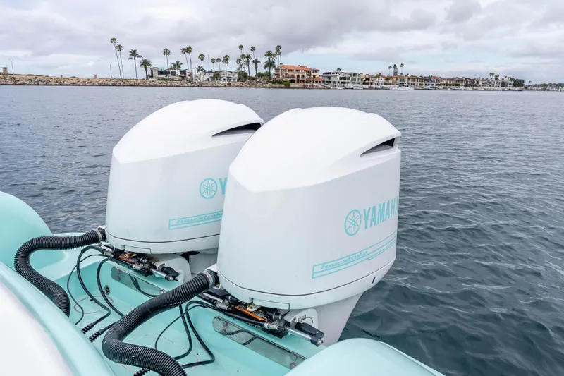 Slide: The Image of Twin Yamaha outboard engines on a 2015 Mag Bay 33 CC boat, coastal background. - 25