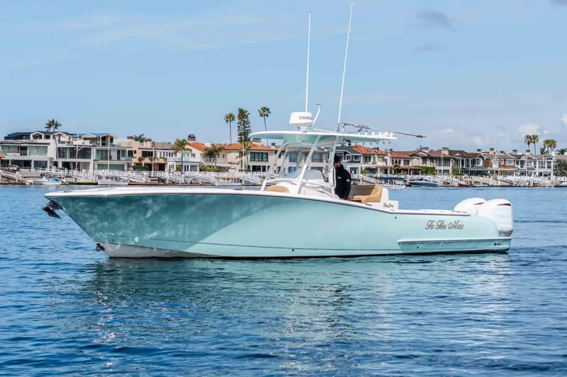 Slide: The Image of 2015 Mag Bay 33 CC boat on calm water near coastal homes. - 6