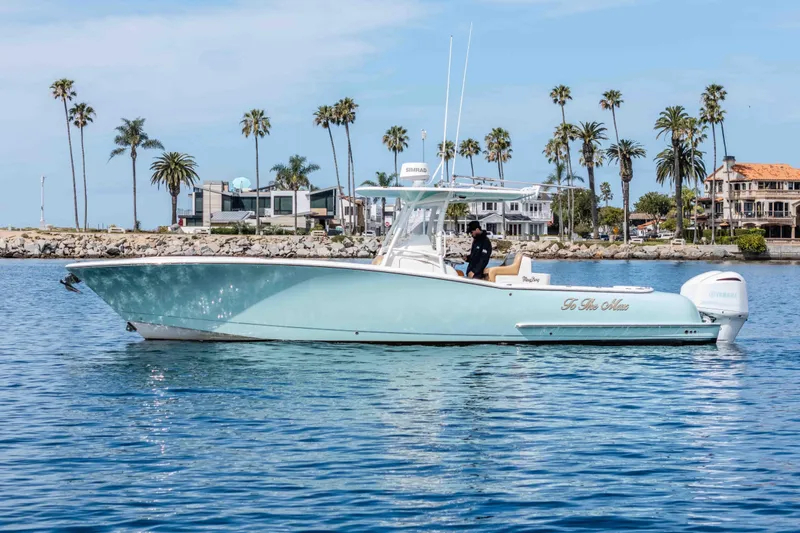 Slide: The Image of 2015 Mag Bay 33 CC boat on calm water with palm trees in background. - 7