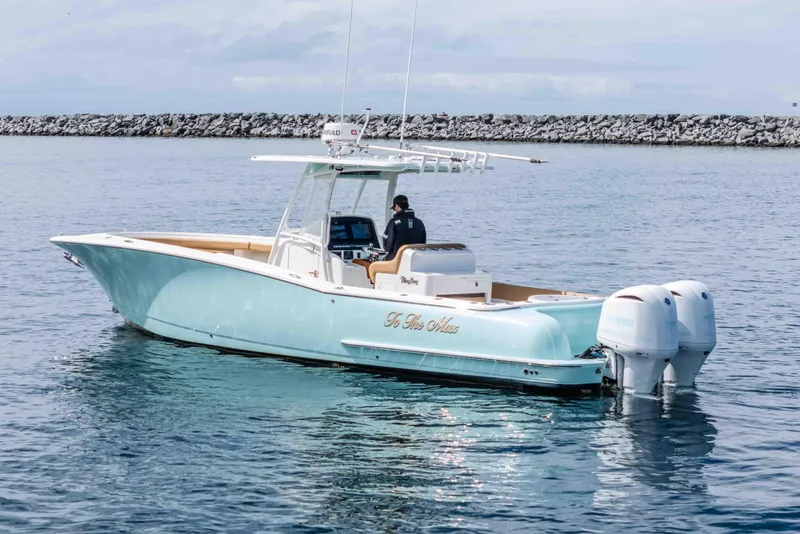 Slide: The Image of 2015 Mag Bay 33 CC boat on calm water with dual outboard engines. - 8