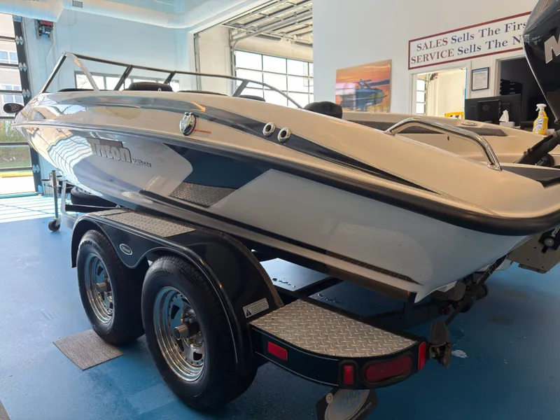 Slide: The Image of 2015 Triton 210 Escape boat on trailer in showroom. - 12