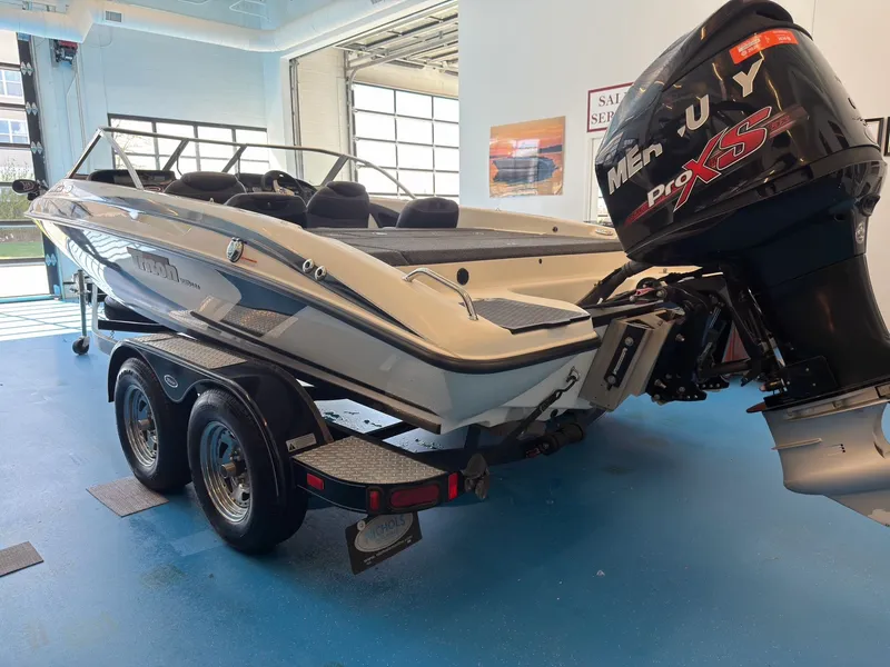 Slide: The Image of 2015 Triton 210 Escape boat with outboard motor in a garage. - 6