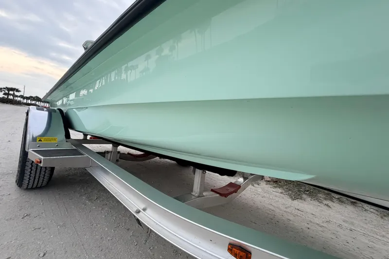 Slide: The Image of 2025 Hell's Bay Professional boat on trailer, side view, light green hull. - 14