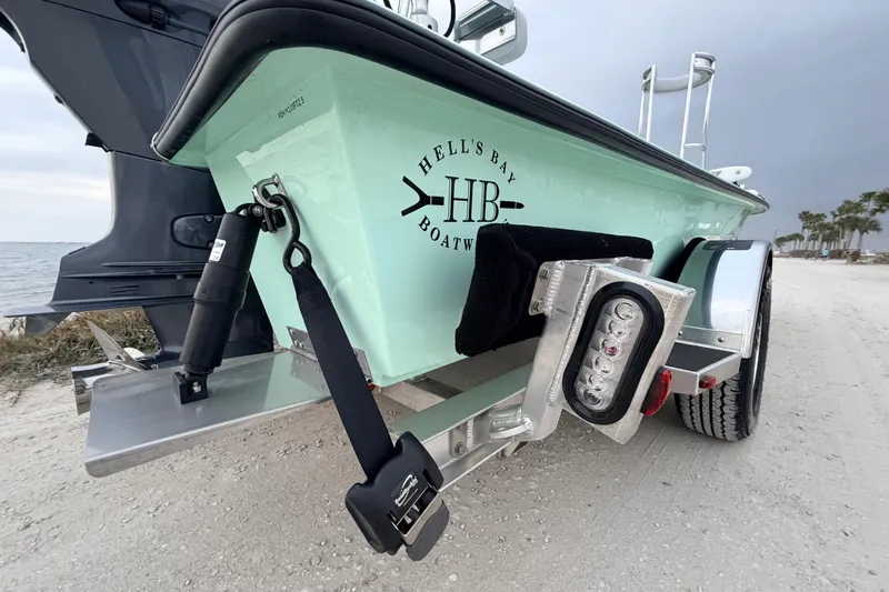 Slide: The Image of 2025 Hell's Bay Professional boat on trailer by the beach, showcasing rear design. - 15