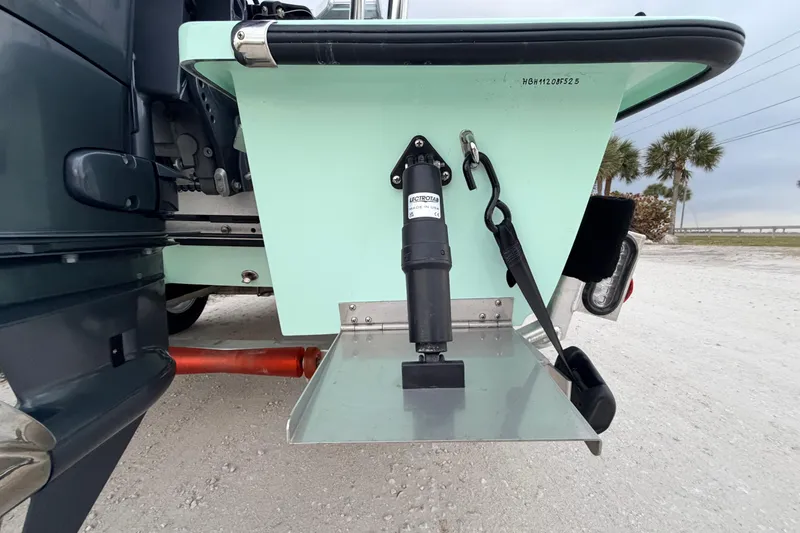 Slide: The Image of 2025 Hell's Bay Professional boat with trim tab mechanism on a sandy beach. - 16