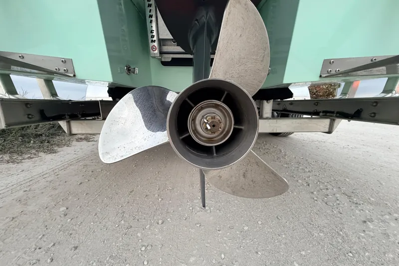 Slide: The Image of Close-up of a 2025 Hell's Bay Professional boat propeller on a sandy surface. - 17