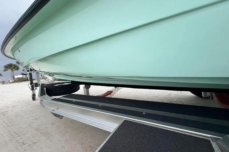 Slide: The Image of 2025 Hell's Bay Professional boat on trailer, parked on sandy beach. - 25