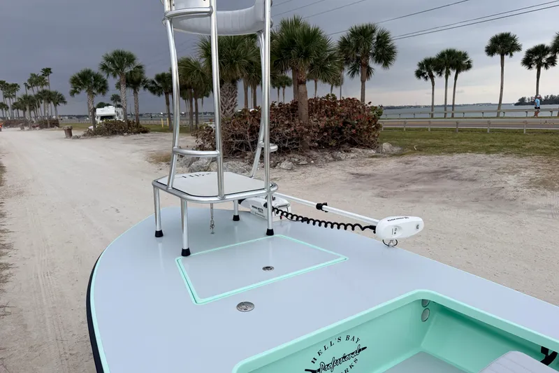 Slide: The Image of 2025 Hell's Bay Professional boat with elevated seat, near palm trees and waterfront. - 26