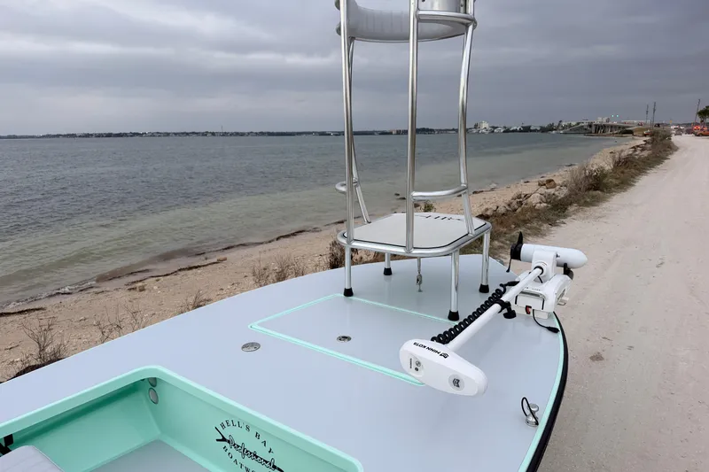 Slide: The Image of 2025 Hell's Bay Professional boat by the shoreline under cloudy skies. - 27