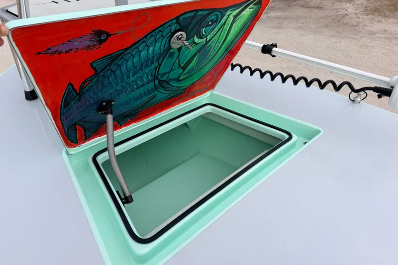 Slide: The Image of 2025 Hell's Bay Professional boat hatch with vibrant fish artwork and open storage compartment. - 33