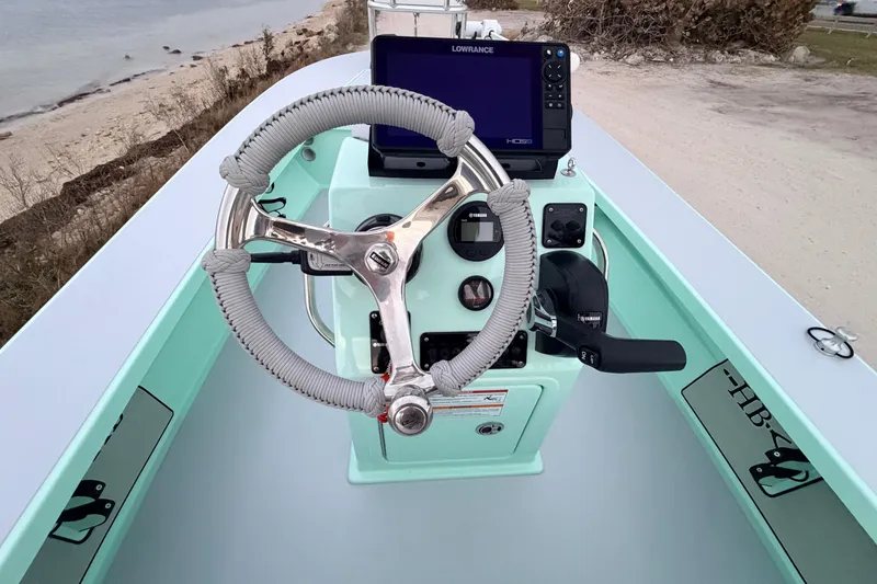 Slide: The Image of 2025 Hell's Bay Professional boat console with steering wheel and navigation equipment. - 49