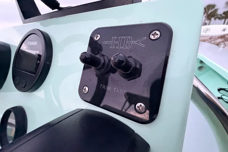 Slide: The Image of Control panel of a 2025 Hell's Bay Professional boat with trim tabs and Yamaha gauge. - 52