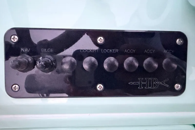 Slide: The Image of Control panel of a 2025 Hell's Bay Professional boat with labeled switches. - 54