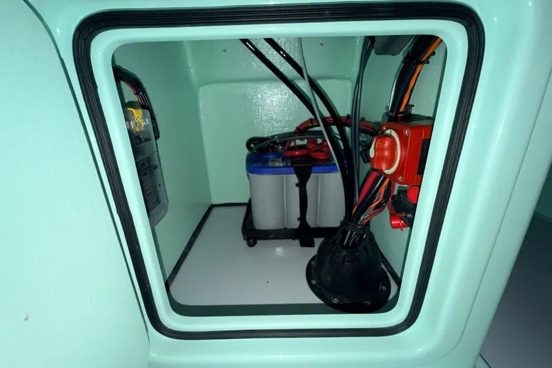 Slide: The Image of Electrical compartment of 2025 Hell's Bay Professional boat, featuring battery and wiring setup. - 58