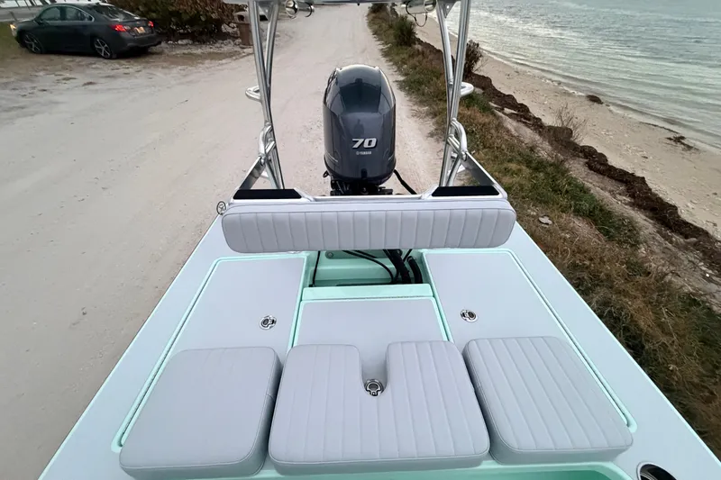Slide: The Image of 2025 Hell's Bay Professional boat with Yamaha 70 engine, parked near a sandy shoreline. - 61