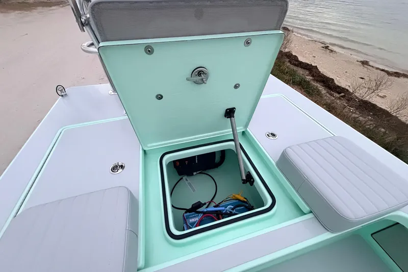 Slide: The Image of 2025 Hell's Bay Professional boat storage compartment with open hatch near shoreline. - 68