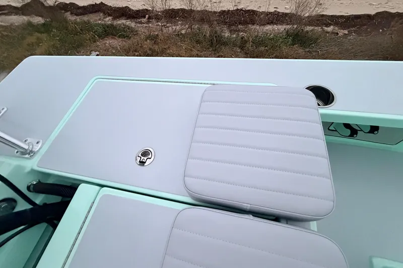 Slide: The Image of 2025 Hell's Bay Professional boat interior with cushioned seating and storage compartment. - 73