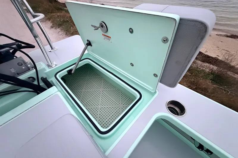 Slide: The Image of 2025 Hell's Bay Professional boat with open storage compartment, near shoreline. - 74