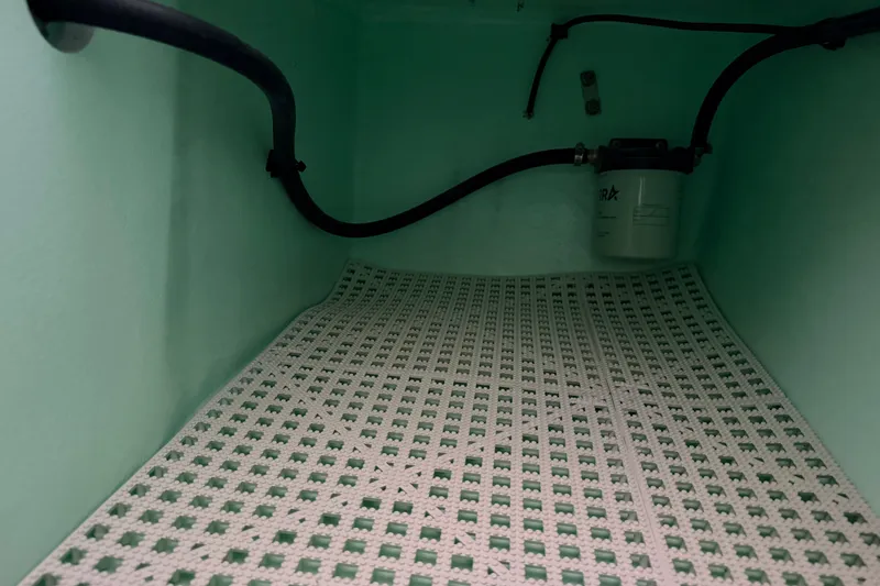 Slide: The Image of Interior view of 2025 Hell's Bay Professional boat compartment with filter and tubing. - 76