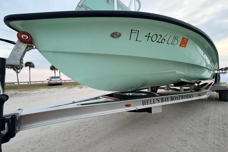 Slide: The Image of 2025 Hell's Bay Professional boat on trailer, parked near beach with palm trees. - 9