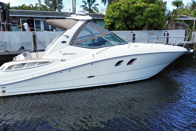 The Image of 2007 Sea Ray Sundancer 310 yacht docked in a serene waterfront setting. - 0