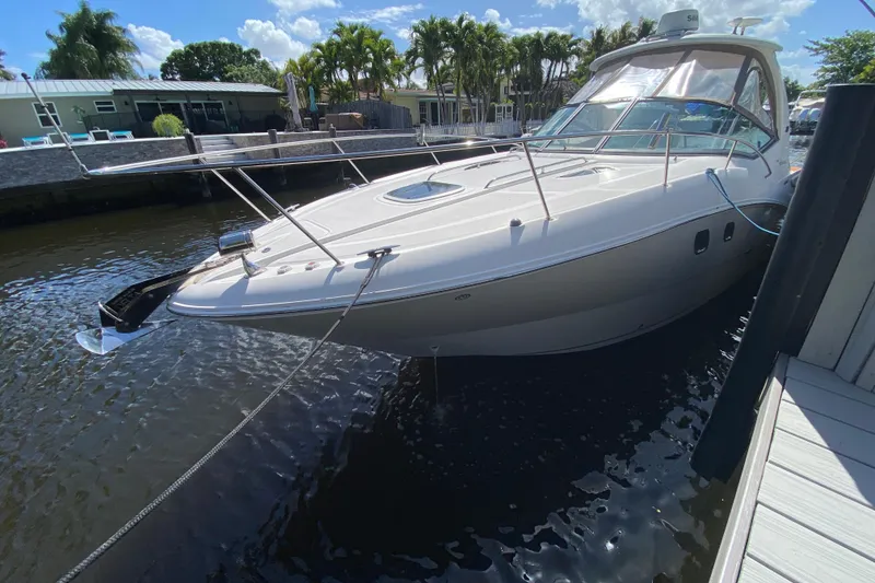 Slide: The Image of 2007 Sea Ray Sundancer 310 docked in a sunny marina, surrounded by lush greenery. - 12
