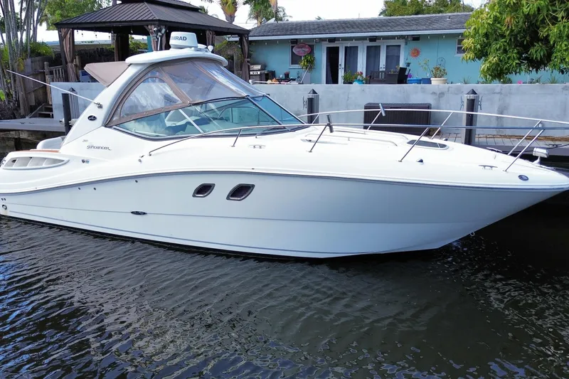 Slide: The Image of 2007 Sea Ray Sundancer 310 yacht docked by a waterfront home. - 2