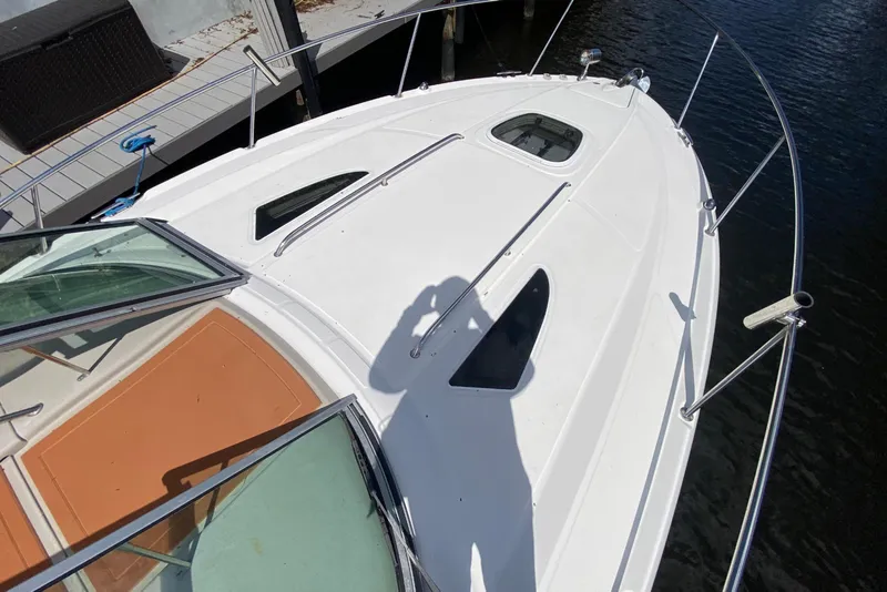 Slide: The Image of 2007 Sea Ray Sundancer 310 yacht docked, showcasing sleek white design and spacious deck. - 24