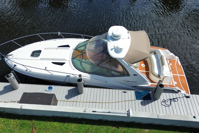 Slide: The Image of 2007 Sea Ray Sundancer 310 docked on calm water, featuring sleek design and spacious deck. - 3