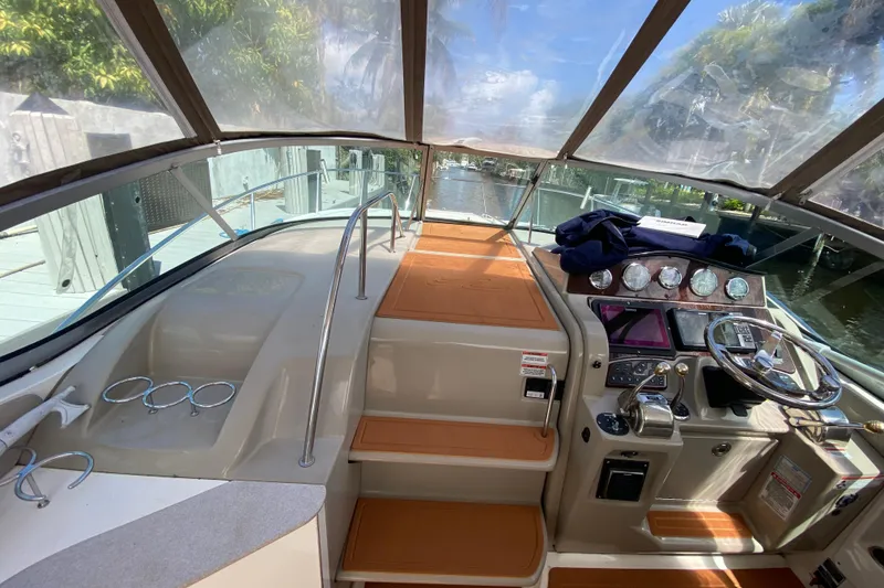 Slide: The Image of 2007 Sea Ray Sundancer 310 cockpit with helm, gauges, and seating under a clear canopy. - 33