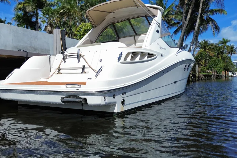 Slide: The Image of 2007 Sea Ray Sundancer 310 yacht docked on a sunny day, surrounded by palm trees. - 45