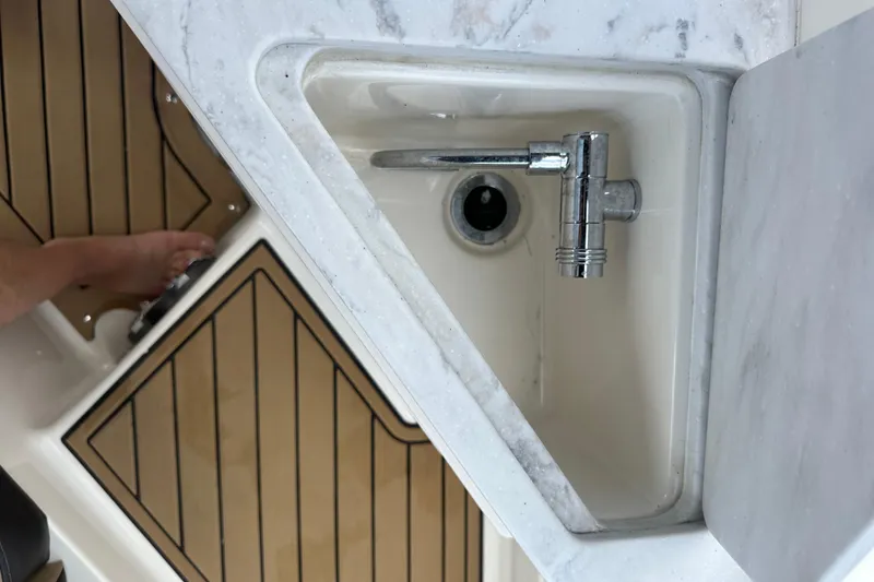 Slide: The Image of Built-in sink on 2022 Sea Ray SDX 290 boat with wooden flooring. - 12