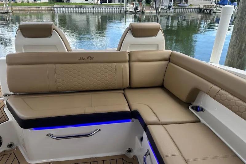 Slide: The Image of 2022 Sea Ray SDX 290 boat interior with tan leather seating and waterfront view. - 14
