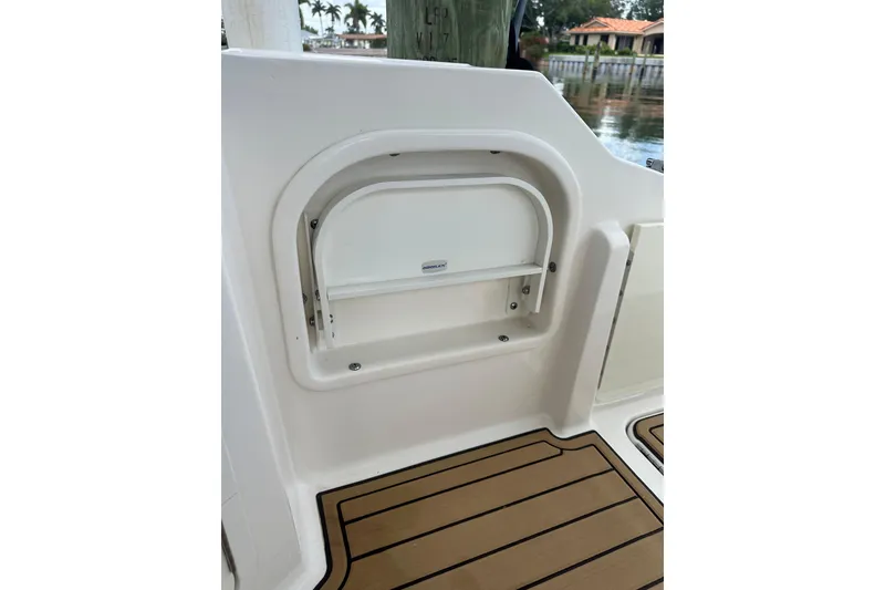 Slide: The Image of 2022 Sea Ray SDX 290 boat interior detail with storage compartment and teak flooring. - 17