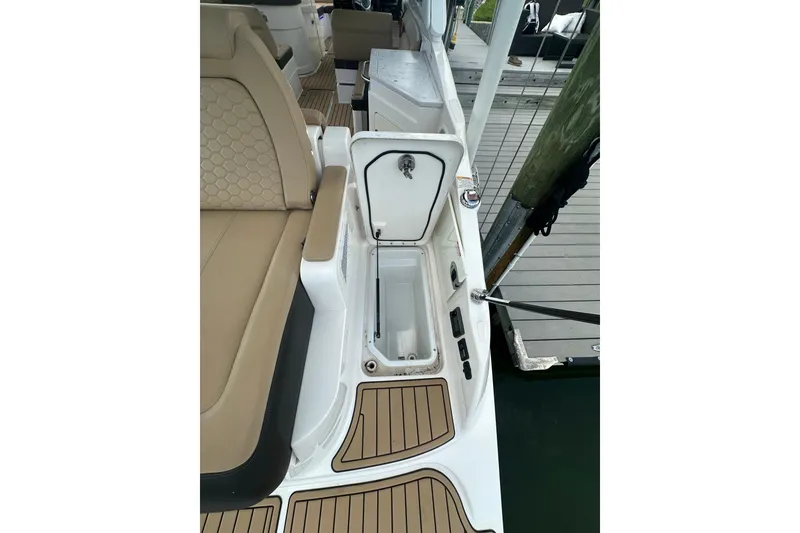 Slide: The Image of 2022 Sea Ray SDX 290 boat interior with open storage compartment and tan seating. - 18