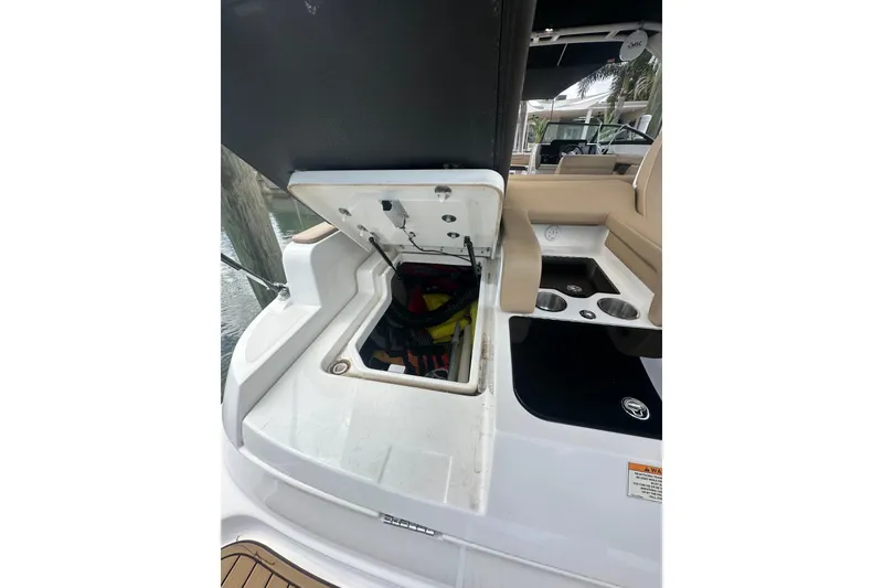 Slide: The Image of 2022 Sea Ray SDX 290 boat with open storage compartment and seating area. - 19