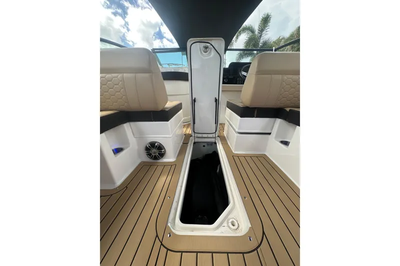 Slide: The Image of 2022 Sea Ray SDX 290 boat interior with open storage compartment and cushioned seating. - 20