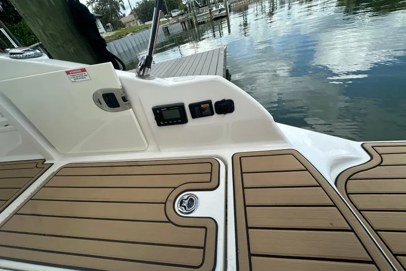 Slide: The Image of 2022 Sea Ray SDX 290 boat deck with wood finish and control panel by the water. - 21