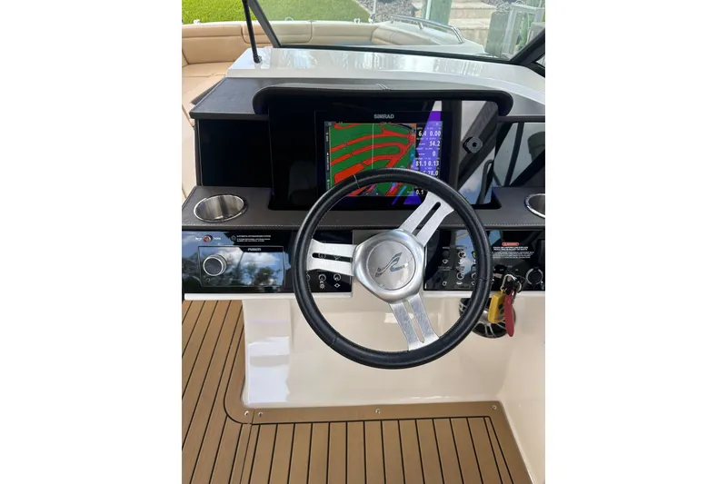 Slide: The Image of 2022 Sea Ray SDX 290 helm with steering wheel and navigation display. - 4